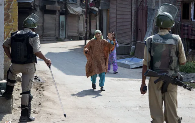 A Kashmiri woman pleads with Indian paramilitary soldiers to let her cross a temporary checkpoint during curfew in Srinagar, Indian controlled Kashmir, Tuesday, July 12, 2016. Curfew imposed in the disputed Himalayan region continues for the fourth consecutive day to suppress anti-India violence following the Friday killing of Burhan Wani, chief of operations of Hizbul Mujahideen, Kashmir's largest rebel group. (Photo by Dar Yasin/AP Photo)