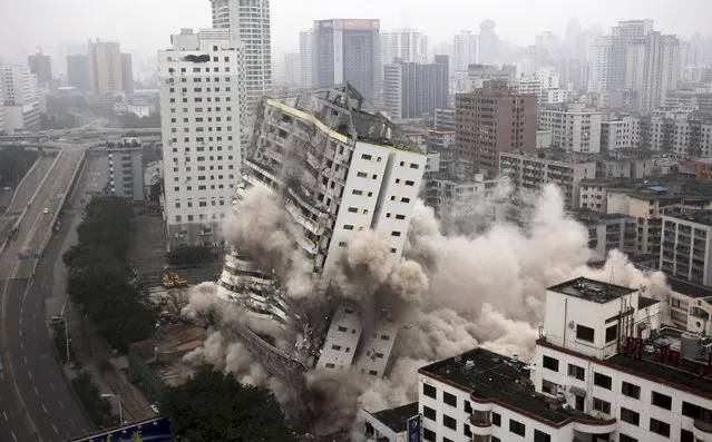 The former Hainan Airlines headquarters topples during a controlled demolition in Haikou, Hainan province, China, December 25, 2012. (Photo by Reuters/China Daily)