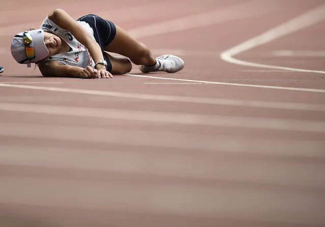 Kim Seongeun of South Korea collapses on the track after finishing the women's marathon at the 15th IAAF Championships in Beijing, China August 30, 2015. (Photo by Dylan Martinez/Reuters)