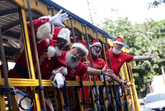 Brazil's Santa Claus school members travel on a Bonde (tram) as they take part in their graduation, ahead of the Christmas season in Rio de Janeiro, Brazil on October 31, 2023. (Photo by Ricardo Moraes/Reuters)