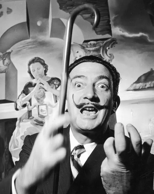 Spanish surrealist artist Salvador Dali (1904–1989) in London with one of his paintings entitled “The Madonna of Port Lligat”, December 1951. (Photo by George Konig/Keystone Features)