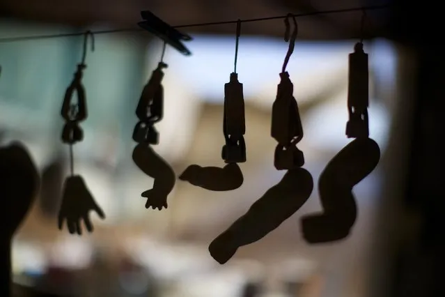 The arms, legs and hands of composition dolls, made from compressed wood chip, are pictured hanging on a line as the paint dries in a workshop of Sydney's Doll Hospital, June 17, 2014. Opened in 1913, Sydney's Doll Hospital has worked on millions of dolls, teddy bears and other toys. (Photo by Jason Reed/Reuters)