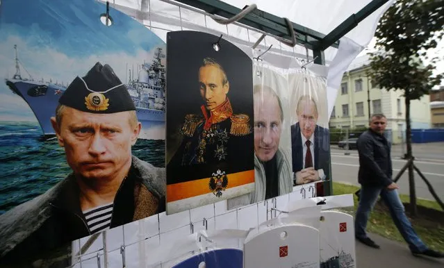 A man walks past cutting boards, that have been painted with images of Russia's President Vladimir Putin, at a street store in the center of St. Petersburg, August 31, 2014. Russia's President Vladimir Putin said on Sunday that Moscow could not stand aside when people were being shot at in Ukraine, he told Russia's state TV Channel 1 in an interview. (Photo by Alexander Demianchuk/Reuters)