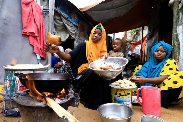 An internally displaced Somali woman and her children prepare their Iftar meal during the month of Ramadan at the Shabelle makeshift camp in Hodan district of Mogadishu, Somalia on April 24, 2020. (Photo by Feisal Omar/Reuters)