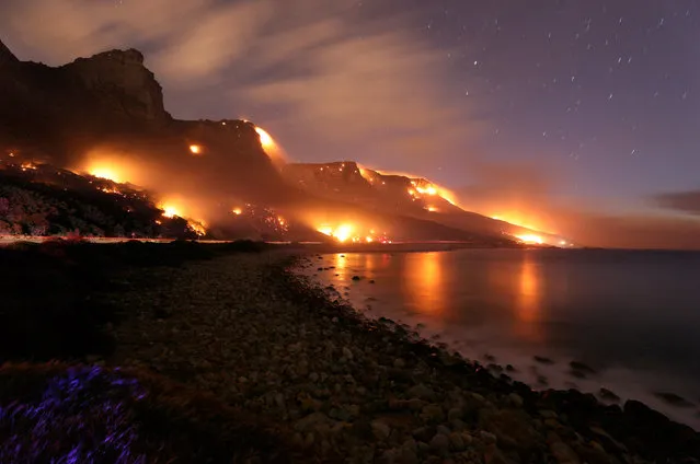 Wildfires burn along the Twelve Apostles area of Table Mountain in Cape Town, South Africa, October 13, 2017. (Photo by Mike Hutchings/Reuters)