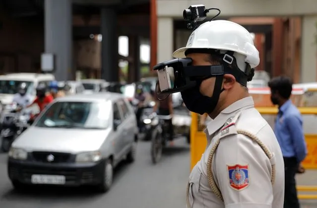 A police officer wears a so called “Thermal Corona Combat Headgear” to monitor the temperature of commuters at a police check post, during a nationwide lockdown to slow the spread of the coronavirus disease (COVID-19), in New Delhi, India on May 11, 2020. (Photo by Adnan Abidi/Reuters)