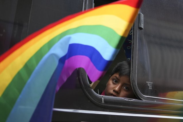 A child looks out from a bus during a campaign rally for Indigenous leader Leonidas Iza, the presidential candidate for the Pachakutik Movement, ahead of the Feb. 9th election, in Cayambe, Ecuador, January 11, 2025. (Photo by Dolores Ochoa/AP Photo)