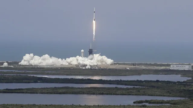 The SpaceX Falcon 9 and the Crew Dragon capsule, with NASA astronauts Bob Behnken and Doug Hurley onboard, lifts off Saturday, May 30, 2020, at the Kennedy Space Center in Cape Canaveral, Fla. (Photo by Chris O'Meara/AP Photo)