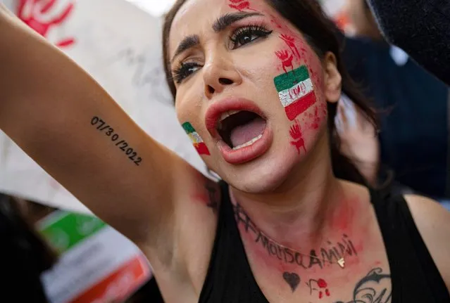 A demonstrator with an Iranian flag painted on her face, shouts slogans as she participates in a rally outside the Iranian consulate in Istanbul on October 17, 2022 after the death of Iranian Mahsa Amini, five weeks ago. Amini, 22, died on September 16, 2022, three days after she was arrested by Iran's notorious morality police. (Photo by Yasin Akgul/AFP Photo)