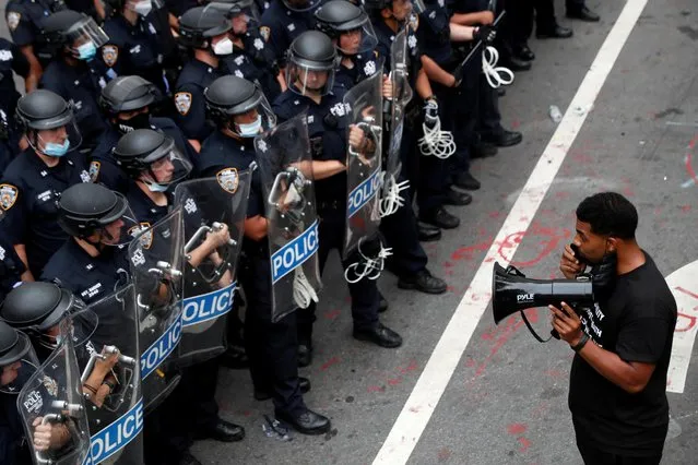 A demonstrator stands in front of New York Police Department (NYPD) officers inside of an area being called the “City Hall Autonomous Zone” that has been established to protest the New York Police Department and in support of “Black Lives Matter” near City Hall in lower Manhattan, in New York City, U.S., July 1, 2020. (Photo by Andrew Kelly/Reuters)