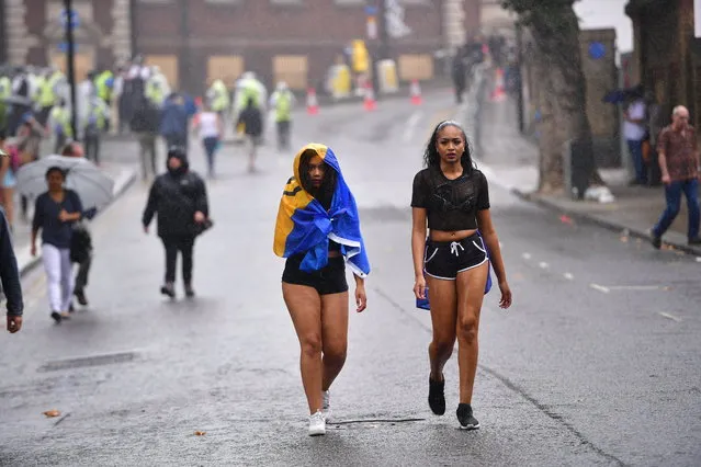 Revellers and carnival goers brave damp conditions as they enjoy family day, the first day of the Notting Hill carnival in London, UK on August 28, 2016. (Photo by Ben Cawthra/London News Pictures)