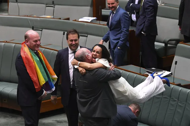 Liberal MP Warren Entsch lifts up Labor MP Linda Burney as they celebrate the passing of the Marriage Amendment Bill in the House of Representatives at Parliament House in Canberra December 7, 2017. (Photo by Lukas Coch/Reuters/AAP)