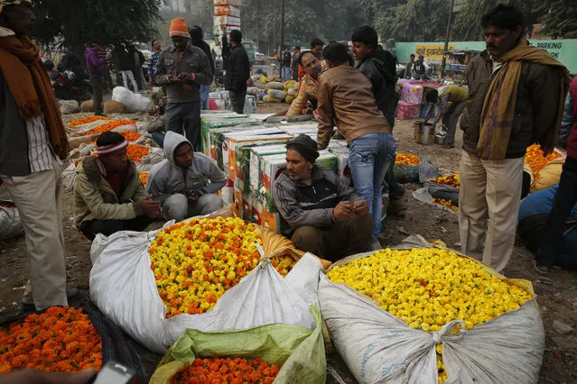 Vendors sell Marigold flowers at a wholesale flower market in Lucknow, Uttar Pradesh, India, Thursday, December 7, 2017. People use marigold flowers for worship in Hindu temples as well as to decorate venues for special occasions. (Photo by Rajesh Kumar Singh/AP Photo)