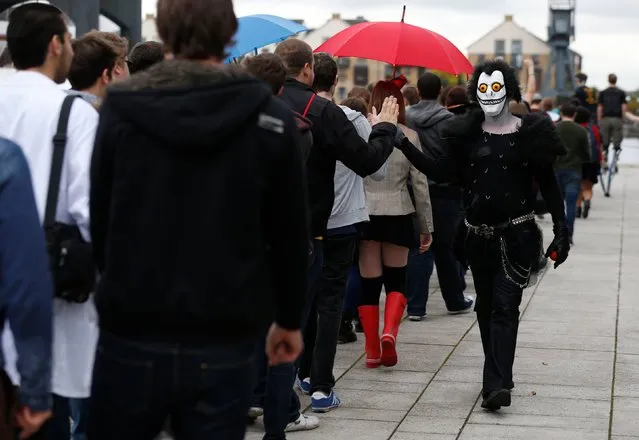 An enthusiast dressed as the character “Ryuk” from Death Note greets visitors on the first day of Comic Con at the Excel Centre, London, on October 24, 2014. (Photo by Jonathan Brady/PA Wire)