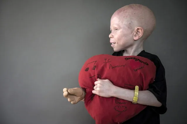 5-year-old Baraka Cosmas from Tanzania poses for a portrait with a plush heart that he says makes him feel safe at night and that he sleeps with. (Photo by Carlo Allegri/Reuters)