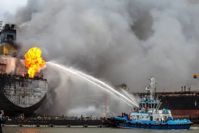 Fire fighters onboard a vessel try to extinguish a fire on a tanker ship docked in Belawan, Indonesia on May 11, 2020. (Photo by Ivan Damanik/AFP Photo)