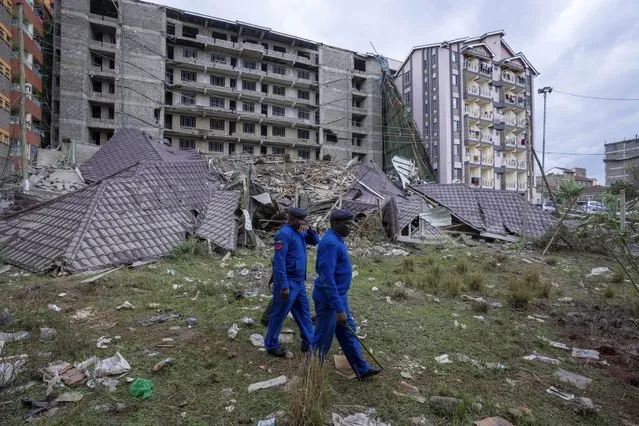 Policemen patrol at the scene of a building collapse in the Kasarani neighborhood of Nairobi, Kenya Tuesday, November 15, 2022. Workers at the multi-storey residential building that was under construction are feared trapped in the rubble and rescue operations have begun, but there was no immediate official word on any casualties. (Photo by Ben Curtis/AP Photo)