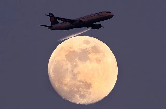 An airplane of German air carrier Lufthansa passes the moon over Frankfurt, Germany, April 9, 2017. (Photo by Kai Pfaffenbach/Reuters)