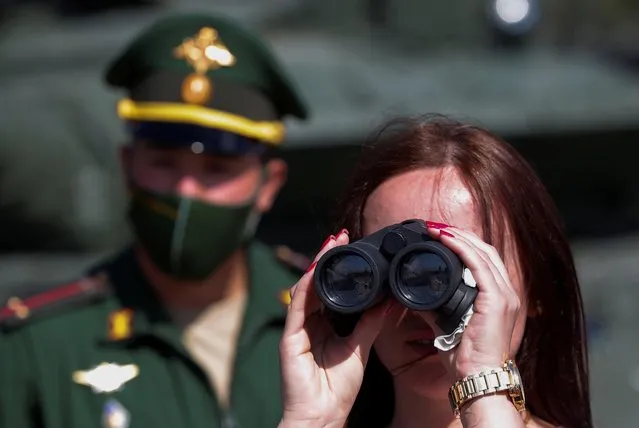 A woman looks through binoculars during the International military-technical forum “Army-2020” at Alabino range in Moscow Region, Russia, August 23, 2020. (Photo by Maxim Shemetov/Reuters)
