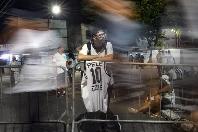 A soccer fans rests after paying his last respects to the late Brazilian soccer great Pele who lies in state at Vila Belmiro stadium in Santos, Brazil, early Tuesday, January 3, 2023. (Photo by Matias Delacroix/AP Photo)