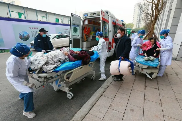 Medical workers receive patients arriving in ambulances at a hospital in Suining in southwestern China's Sichuan province on Saturday, December 31, 2022. China is on a bumpy road back to normal life as schools, shopping malls and restaurants fill up again with the easing of COVID-19 restriction. The abrupt end to testing and other measures came as hospitals were swamped with feverish, wheezing COVID-19 patients. (Photo by Chinatopix via AP Photo)