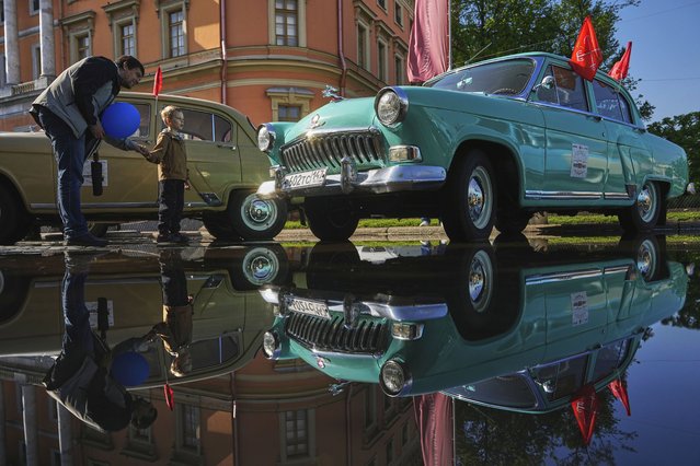 A man and a child examine a Soviet era GAZ M21 Volga car at a transport festival in St. Petersburg, Russia, Saturday, May 24, 2025. (Photo by Dmitri Lovetsky/AP Photo)