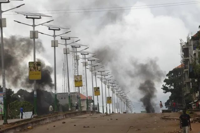 Smoke billows on a street in Bambeto during a protest after opposition candidates called on Monday for the results of the election to be scrapped due to fraud, in Conakry October 13, 2015. (Photo by Luc Gnago/Reuters)