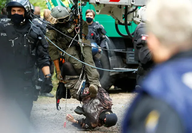 A police special forces officer brings down a protester staging a blockade as the police and forest workers clear a camp at the Dannenrod forest during a protest of environmentalists against the extension of the highway Autobahn 49, in Dannenrod, Germany on September 16, 2020. (Photo by Kai Pfaffenbach/Reuters)