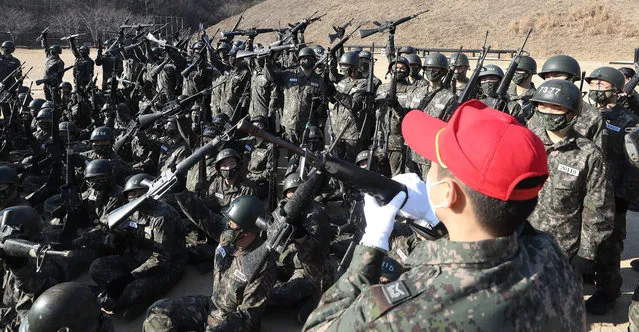 South Korean Navy conscripts are taught how to grip their rifles by an instructor (wearing a red cap) ahead of a training session to learn individual combat skills at a boot camp in the southeastern city of Changwon, South Korea, 04 January 2023. In South Korea, all able-bodied young men are required to serve roughly 18 months of military service. (Photo by Yonhap/EPA/EFE/Rex Features/Shutterstock)
