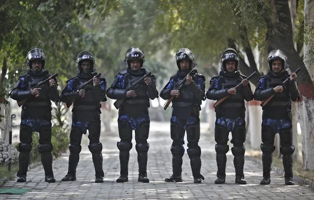 India's Rapid Action Force (RAF) personnel pose for pictures inside their base camp in New Delhi November 6, 2014. In India, the RAF are called on for violent disorder that the police are unable to contain. They require an on-the-spot magistrate's consent and must issue a warning before each escalation of the use of force, from verbal warning to water cannon and tear gas, then to rubber bullets or baton rounds, and then to firearms. (Photo by Adnan Abidi/Reuters)