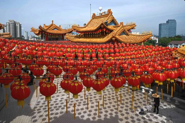 A cleaner cleans the floor under the red lanterns of Chinese New Year decorations at the Thean Hou Temple ahead of the Lunar New Year celebrations, which marks the year of the rabbit, in Kuala Lumpur on January 3, 2023. (Photo by Mohd Rasfan/AFP Photo)