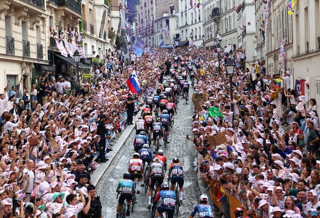 Spectators cheer on the peloton during the final stage of the Tour de France in Paris on July 27, 2025, as they climb the Montmartre hill that was the centrepiece of the Olympics road race last year. (Photo by Abdul Saboor/Reuters)