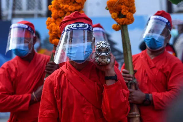 Devotees carry jamara plants used for blessings during the Fulpati procession marking the seventh day of the Nepali Hindu festival “Dashain” in Kathmandu on October 23, 2020. (Photo by Prakash Mathema/AFP Photo)