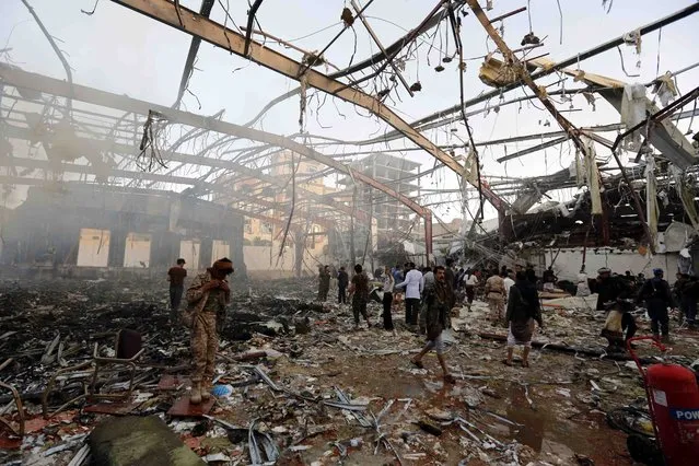 People inspect the aftermath of a Saudi-led coalition airstrike in Sanaa, Yemen, Saturday, October 8, 2016. Yemeni security and medical officials say at least 45 people have been killed in a Saudi-led coalition airstrike that targeted a funeral hall in the capital, Sanaa. The officials say at least another 100 have been wounded in the Saturday strike. (Photo by Osamah Abdulrhman/AP Photo)