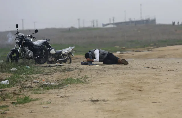 A wounded Palestinian youth lies on the ground waiting for medics during clashes with Israeli soldiers on the Israeli border Eastern Gaza City, Friday, November 6, 2015. (Photo by Adel Hana/AP Photo)