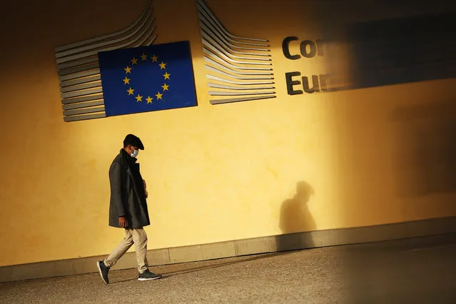 A mans shadow falls onto the facade of EU headquarters in Brussels as he walks by in the sun, Tuesday, December 8, 2020. Britain and the European Union warned Tuesday that talks on a post-Brexit free-trade deal are teetering on the brink of collapse, with just over three weeks until an economic rupture that will cause upheaval for businesses on both sides of the English Channel. (Photo by Francisco Seco/AP Photo)