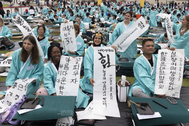People participate in a Hangul calligraphy competition during a celebration of the 579th anniversary of Hangul Day at Gwanghwamun Square in Seoul, South Korea, 09 October 2025. South Korea celebrates the 579th anniversary of the invention of the Korean alphabet, called “hangeul”, which was created by King Sejong during the Joseon Dynasty between 1392 and 1910. (Photo by Jeon Heon-Kyun/EPA)
