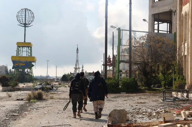 Rebel fighters walk around al-Hamidiyeh base, one of two military posts they took control of from forces loyal to Syria's President Bashar al-Assad in the northwestern province of Idlib, December 15, 2014. (Photo by Reuters/Stringer)