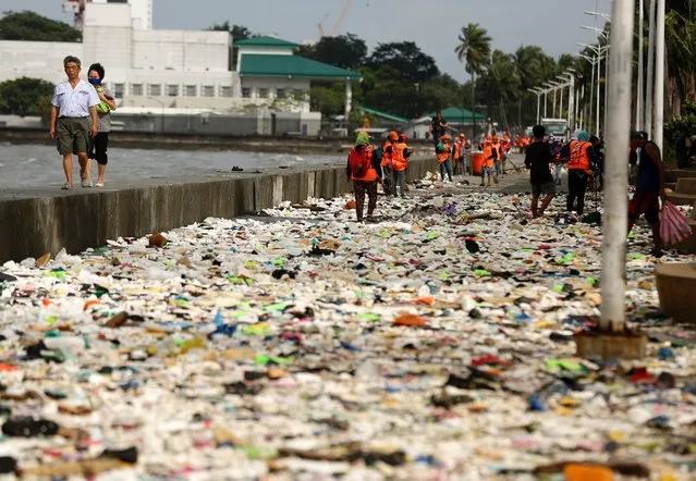 Filipino government personnel collect rubbish washed in by waves created by Typhoon Haima along Manila Bay, Manila, Philippines, October 20, 2016. (Photo by Eugenio Loreto/EPA)