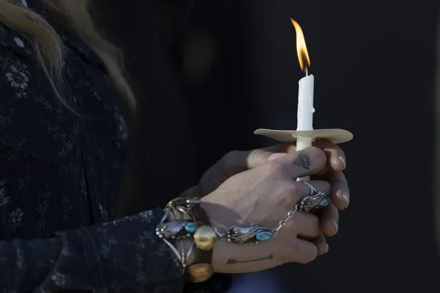 A lady holds a candle during a vigil held for victims of The Covenant School shooting on Wednesday, March 29, 2023, in Nashville, Tenn. (Photo by Wade Payne/AP Photo)