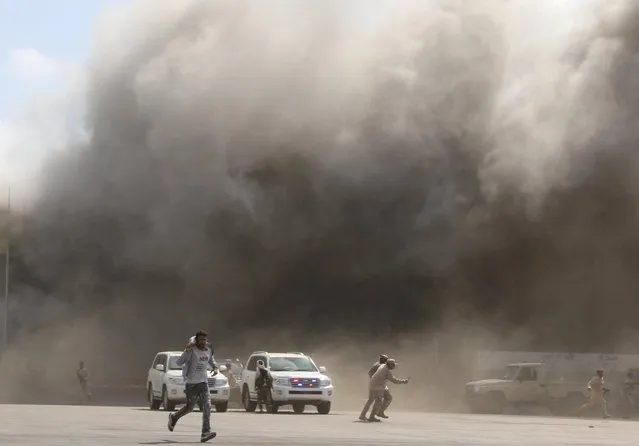 People react as dust rises after explosions hit Aden airport, upon the arrival of the newly-formed Yemeni government in Aden, Yemen on December 30, 2020. (Photo by Fawaz Salman/Reuters)