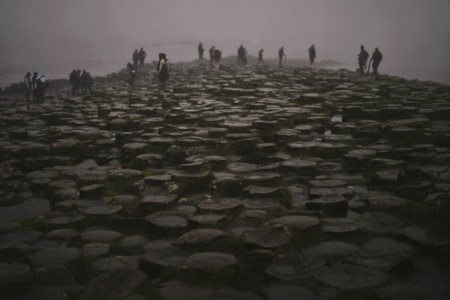 Tourists visit the Giant's Causeway near Bushmills, County Antrim, Northern Ireland, Monday, July 21, 2025. (Photo by Francisco Seco/AP Photo)