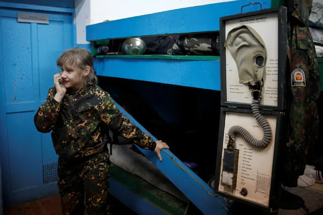 A girl stands near a model showing the organization of a gas mask during military training undergone by students of the General Yermolov Cadet School and members of a Cossack community at a boot camp of the Russkiye Vityazi (Russian Knights) military patriotic club in the village of Sengileyevskoye in Stavropol region, Russia, November 1, 2016. (Photo by Eduard Korniyenko/Reuters)