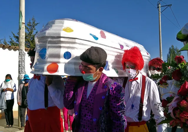 Admirers of Peruvian clown William Rojas, known professionally as “Chupetin”, carry his coffin during his funeral procession to the Eternal Hope cemetery in Huancayo, Peru, on July 2, 2020. Rojas, 45, died from COVID-19 after five days of being in intensive care. Peru surpassed 10,000 deaths from the coronavirus on Thursday, the health ministry said, a day after the government began easing a national lockdown in a bid to revive the economy. (Photo by Pedro Tinoco/AFP Photo)