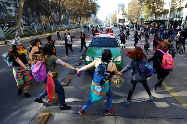 Demonstrators surround a police vehicle during a march demanding an end to sexism and gender violence in Santiago, Chile June 6, 2018. (Photo by Ivan Alvarado/Reuters)