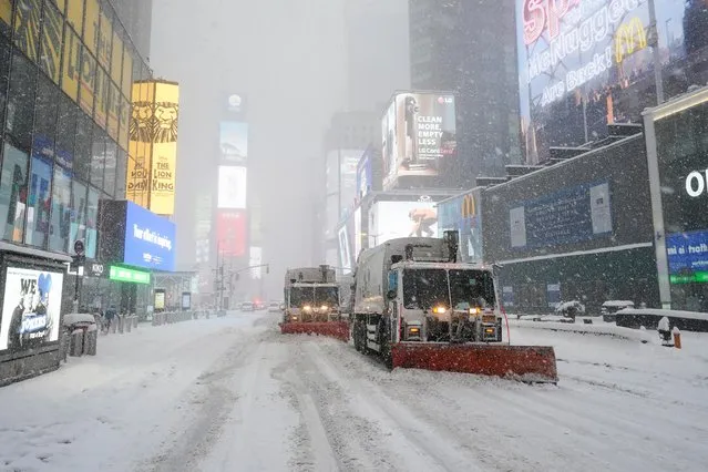 Snowploughs remove snow from the Times Square during a snow storm, amid the coronavirus disease (COVID-19) pandemic, in the Manhattan borough of New York City, New York, U.S., February 1, 2021. (Photo by Carlo Allegri/Reuters)
