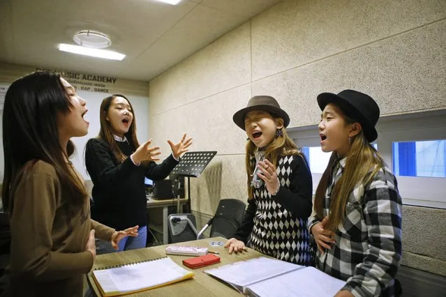 Kim Si-yoon (2nd R) and Yoo Ga-eul (R) take part in a singing lesson at DEF Dance Skool in Seoul November 15, 2014. Nine-year-old Kim has no time to throw tantrum. (Photo by Kim Hong-Ji/Reuters)