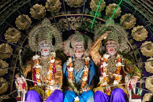 Indian artists dressed as Hindu deities Rama, left, Sita, center, and Laxman, right sit in a tableau during a Dussehra festival procession early morning in Prayagraj, Uttar Pradesh, India, Tuesday, October 8, 2024. (Photo by Rajesh Kumar Singh/AP Photo)