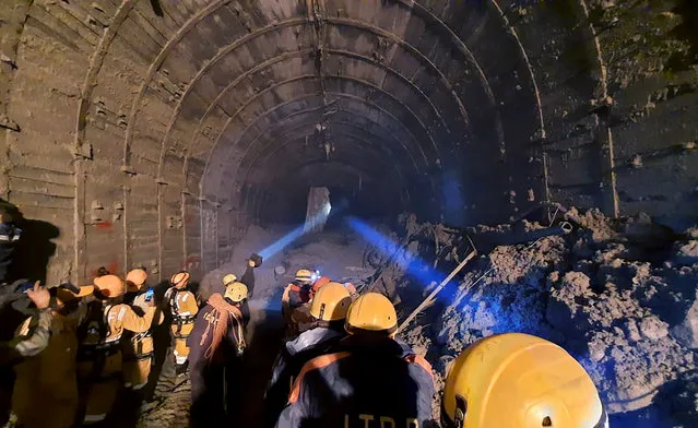 This photograph provided by Indo Tibetan Border Police (ITBP) shows ITBP personnel use torches to gain access inside a tunnel to rescue more than three dozen power plant workers trapped inside it after part of a Himalayan glacier broke off Sunday and sent a wall of water and debris rushing down the mountain in Tapovan area of the northern state of Uttarakhand, India, Tuesday, February 9, 2021. Hundreds of rescue workers were scouring muck-filled ravines and valleys in northern India on Tuesday looking for survivors after part of a Himalayan glacier broke off, unleashing a devastating flood that has left at least 31 people dead and 165 missing. (Photo by Indo Tibetan Border Police via AP Photo)