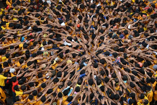 “Hands of Unity”. Young people press together to build a human pyramid during Janmashtami, the birth anniversary of the Hindu god Krishna, in Mumbai, India. The object of the game, called Dahi Handi, is to catch and break an earthen pot hanging above the pyramid. (Photo and caption by Sudeep Mehta/National Geographic Traveler Photo Contest)